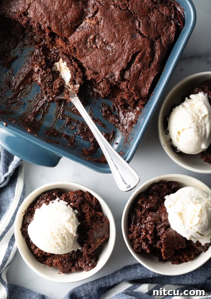 Decadent Chocolate Pudding Cake 3 3 white bowls with servings of chocolate lava cake and a scoop of vanilla ice cream. Bowls are next to a baking pan with pudding cake and a metal spoon.