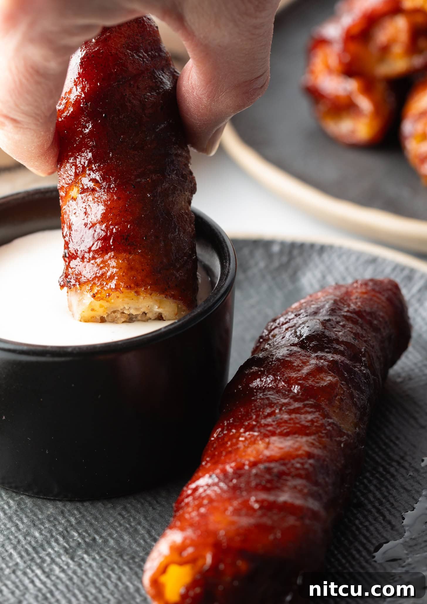 Smoked & Loaded Shells 13 Hand dipping a smoked shotgun shell into a creamy white sauce.
