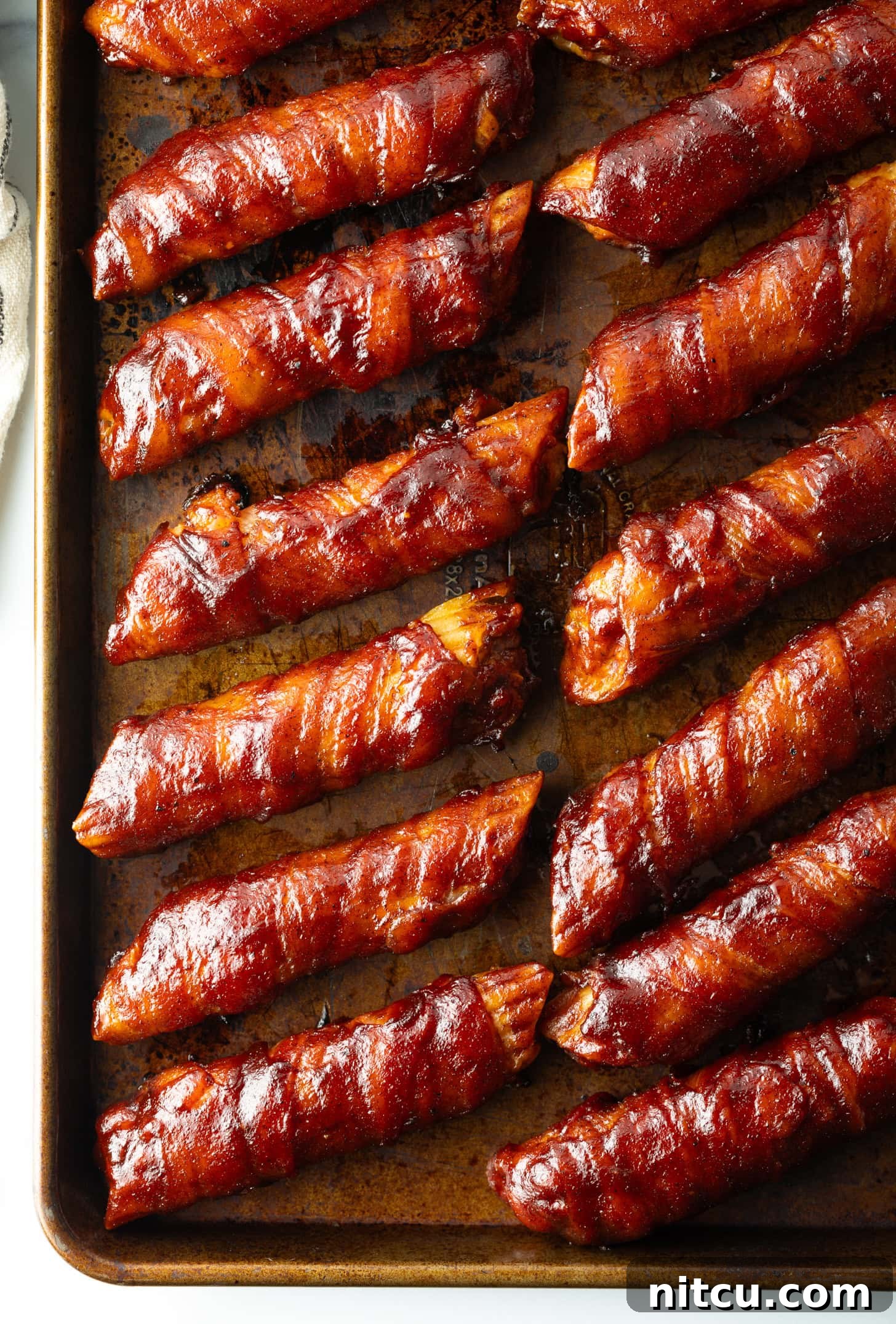 Smoked & Loaded Shells 4 Top down view of 14 bacon wrapped smoked shells on a baking pan.