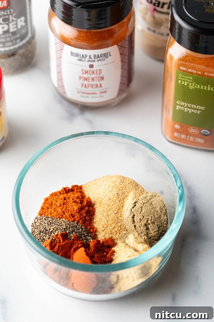 Perfectly Smoked Traeger Turkey Breast 5 Glass bowl with assortment of smoked turkey rub spices: garlic, paprika powder, sage, onion powder, black pepper, cayenne pepper.