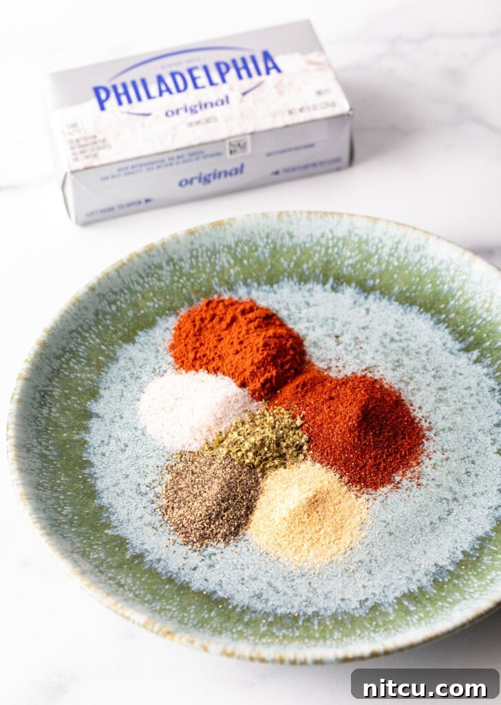 Green plate with piles of spices: Chili powder, paprika, thyme, garlic powder, salt and pepper.