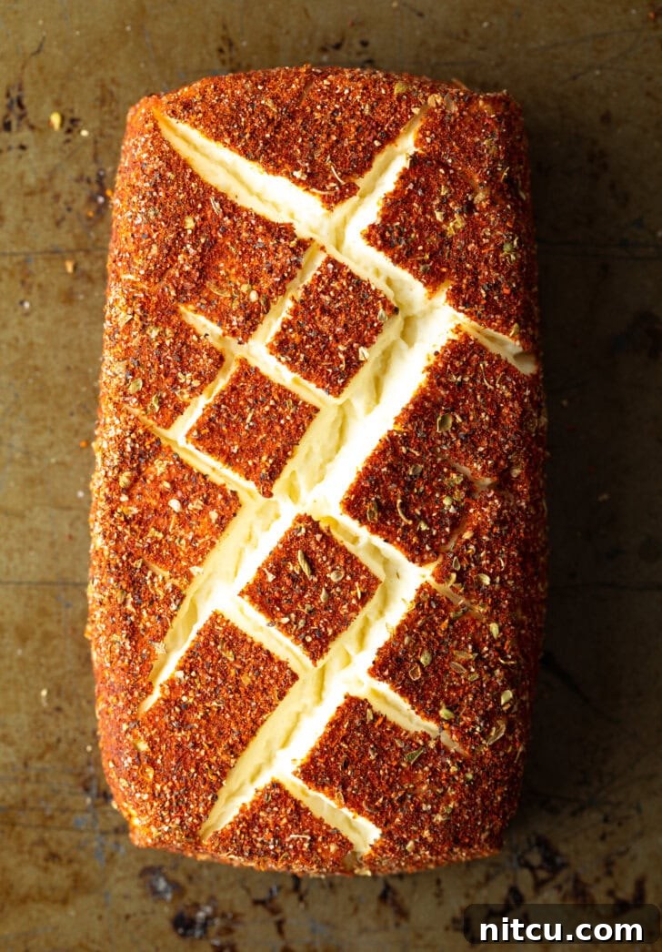 Top down view of a block of spice-coated smoked cream cheese.