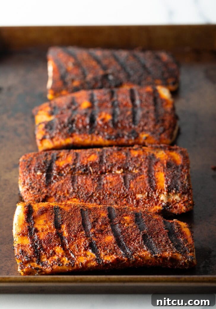 Fiery Blackened Mahi Delight 7 4 large fillets of grilled fish on a baking sheet coated with blackening seasoning.