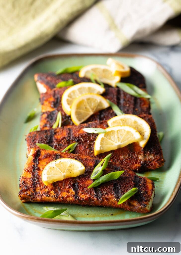 Fiery Blackened Mahi Delight 8 4 pieces of blackened and grilled fish, all topped with slices of lemon and green onions.