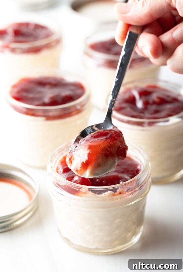 High-Protein Yogurt Pudding 8 Metal spoonful of protein yogurt and raspberry jam to camera.