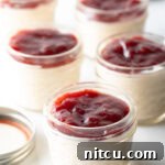 High-Protein Yogurt Pudding 9 5 small glass jars of protein pudding topped with raspberry jam.