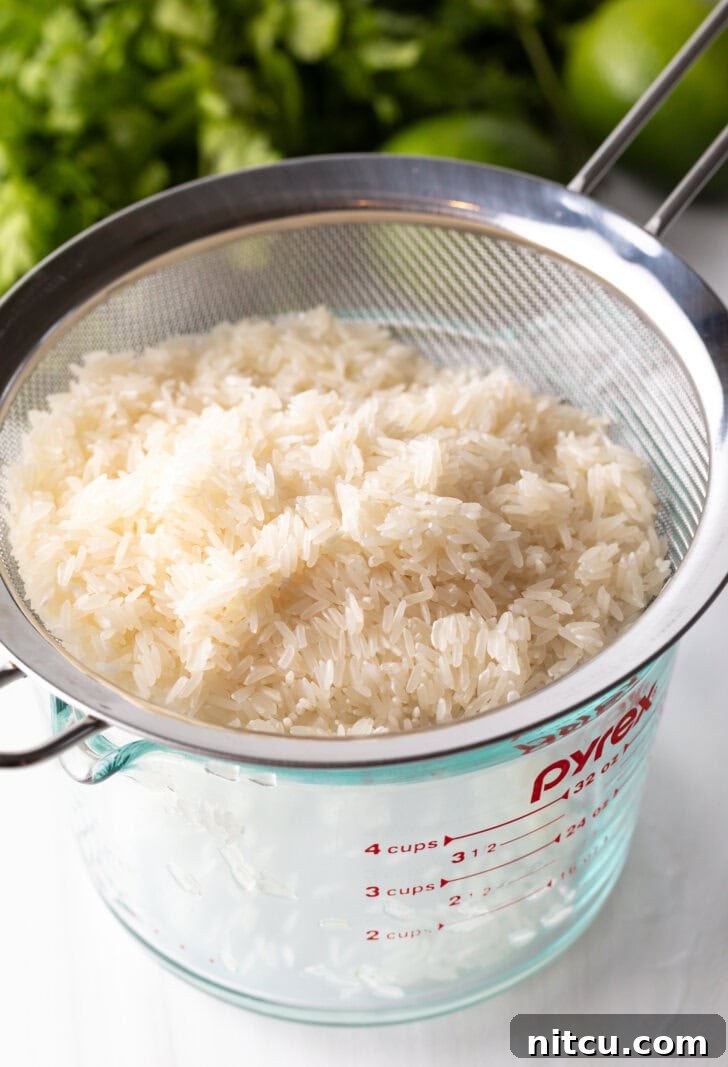 Homemade Chipotle Cilantro Lime Rice 5 Straining white rice over a glass measuring pitcher.