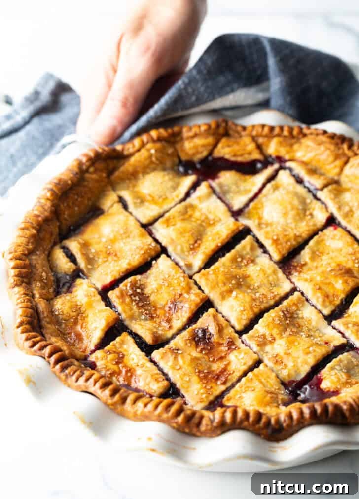 Sweet Cherry Pie Delight 12 A vibrant cherry pie with a beautifully baked golden crust, just out of the oven, radiating warmth and delicious aroma.