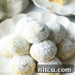 Pyramid stacks of almond and pistachio Italian wedding cookies dusted with powdered sugar.