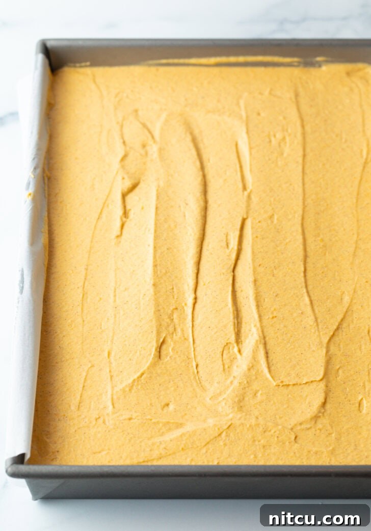 Sheet Pan No-Bake Pumpkin Cheesecake 9 Smooth pumpkin cheesecake in a rectangle baking dish.