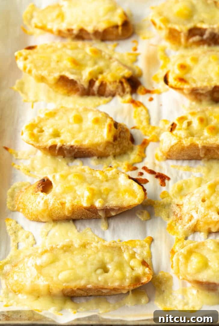 Bistro Onion Comfort 10 10 slices of baguette on a baking sheet, topped with melted cheese after broiling.