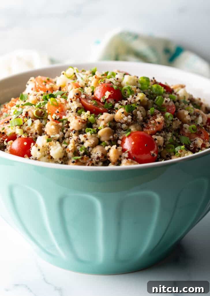 Perfectly Fluffy Quinoa 3 Bowl of quinoa salad with cherry tomatoes, chopped fresh herbs, and chickpeas.