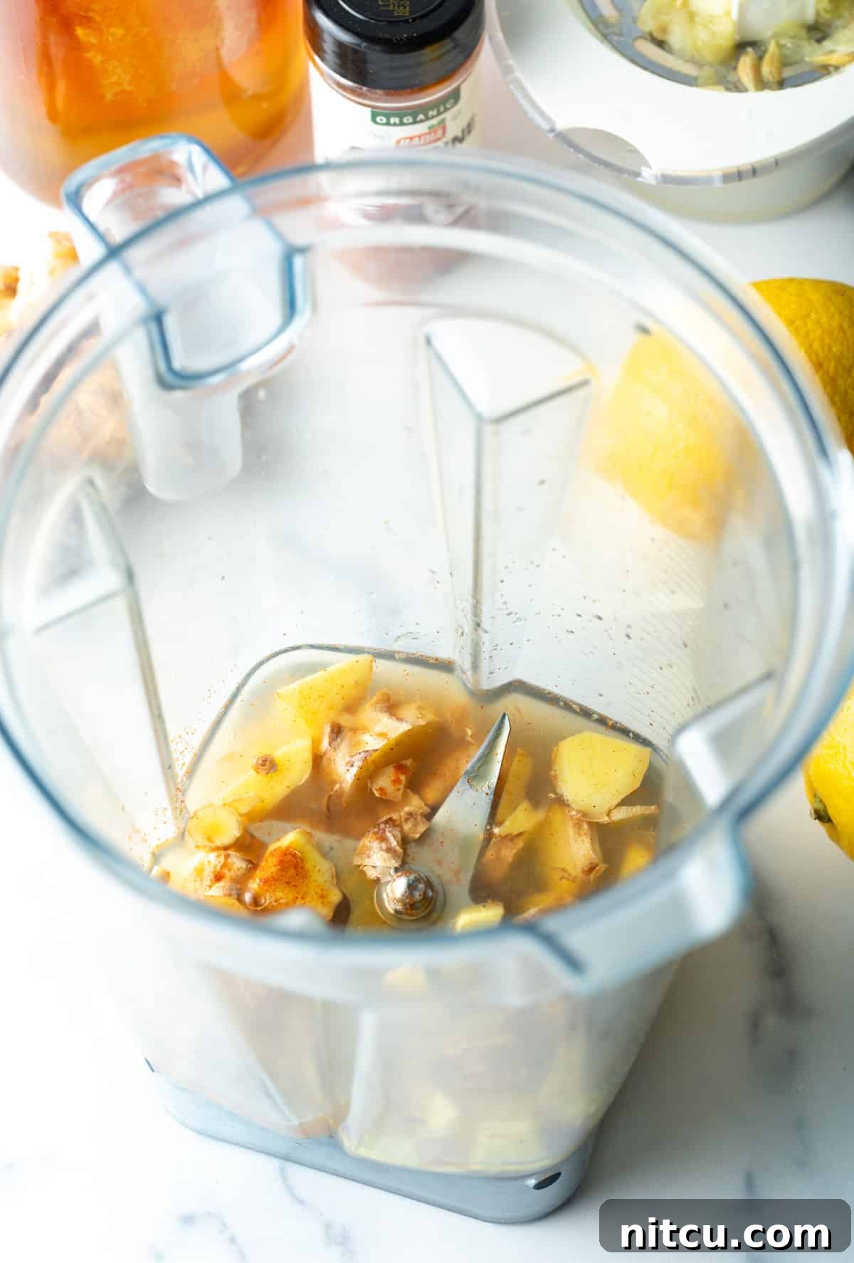 Ginger Zinger Immunity Elixir 4 Garlic, lemon, turmeric, in a food processor, ready to be blended for the ginger shot.