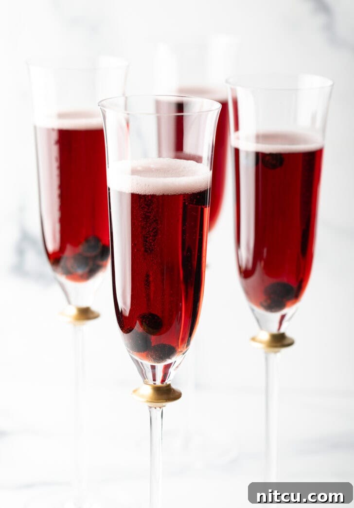 Regal Berry Fizz 10 A festive spread featuring four Kir Royale cocktails alongside an assortment of appetizers, perfect for a gathering.