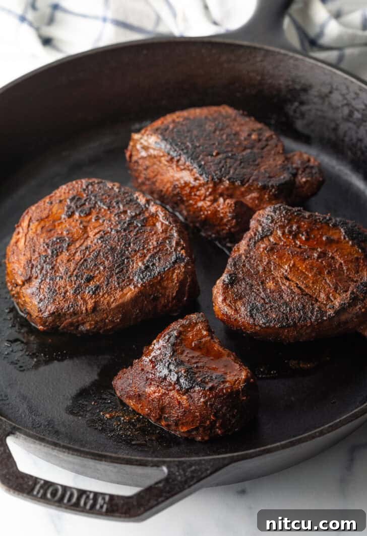 Achieve Steakhouse Quality with Reverse Searing 6 4 filets searing in a cast iron skillet.