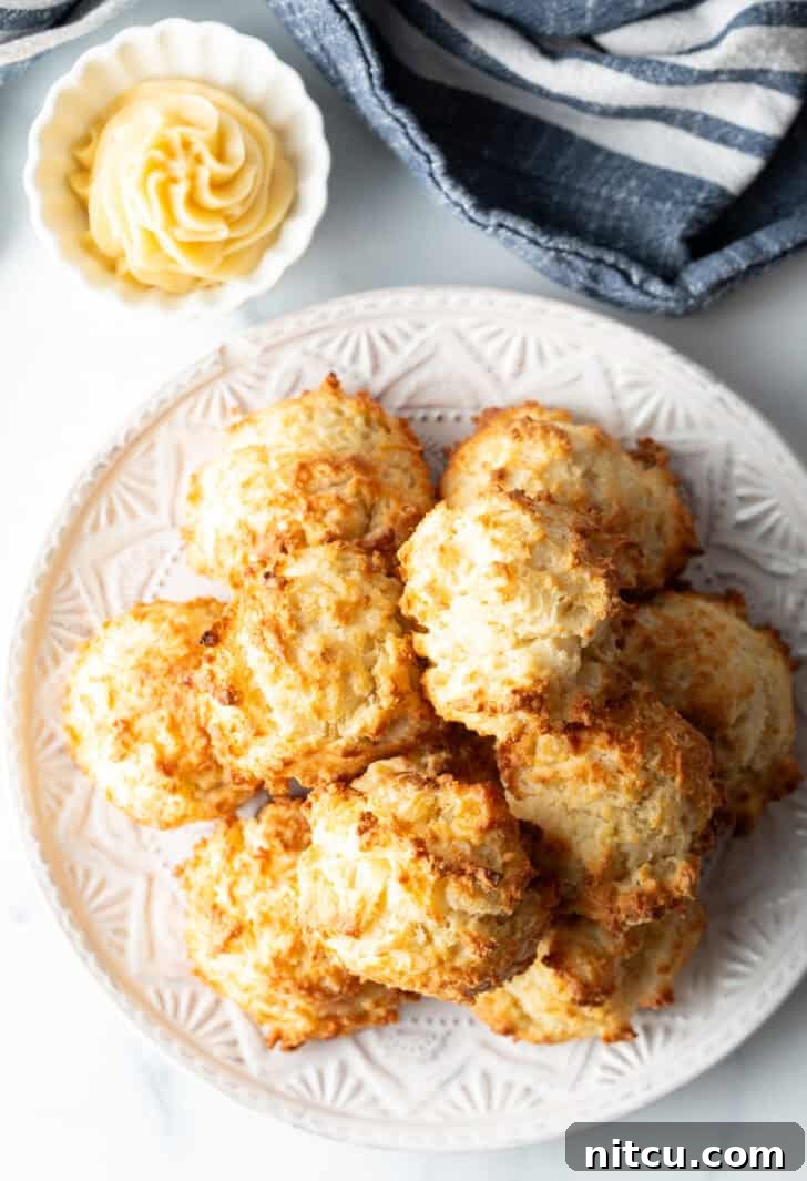 Pillowy Buttermilk Drop Biscuits 11 Top down view white plate with two-layer high stack of several homemade buttermilk biscuits.
