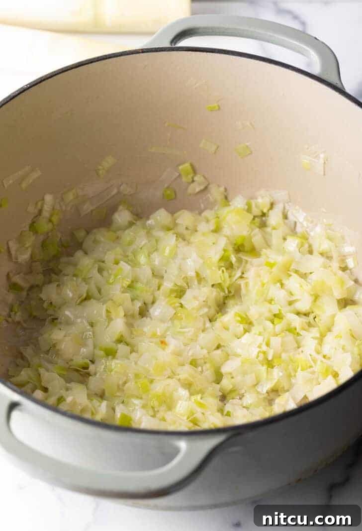 Cooking shaved leeks in a large pot.