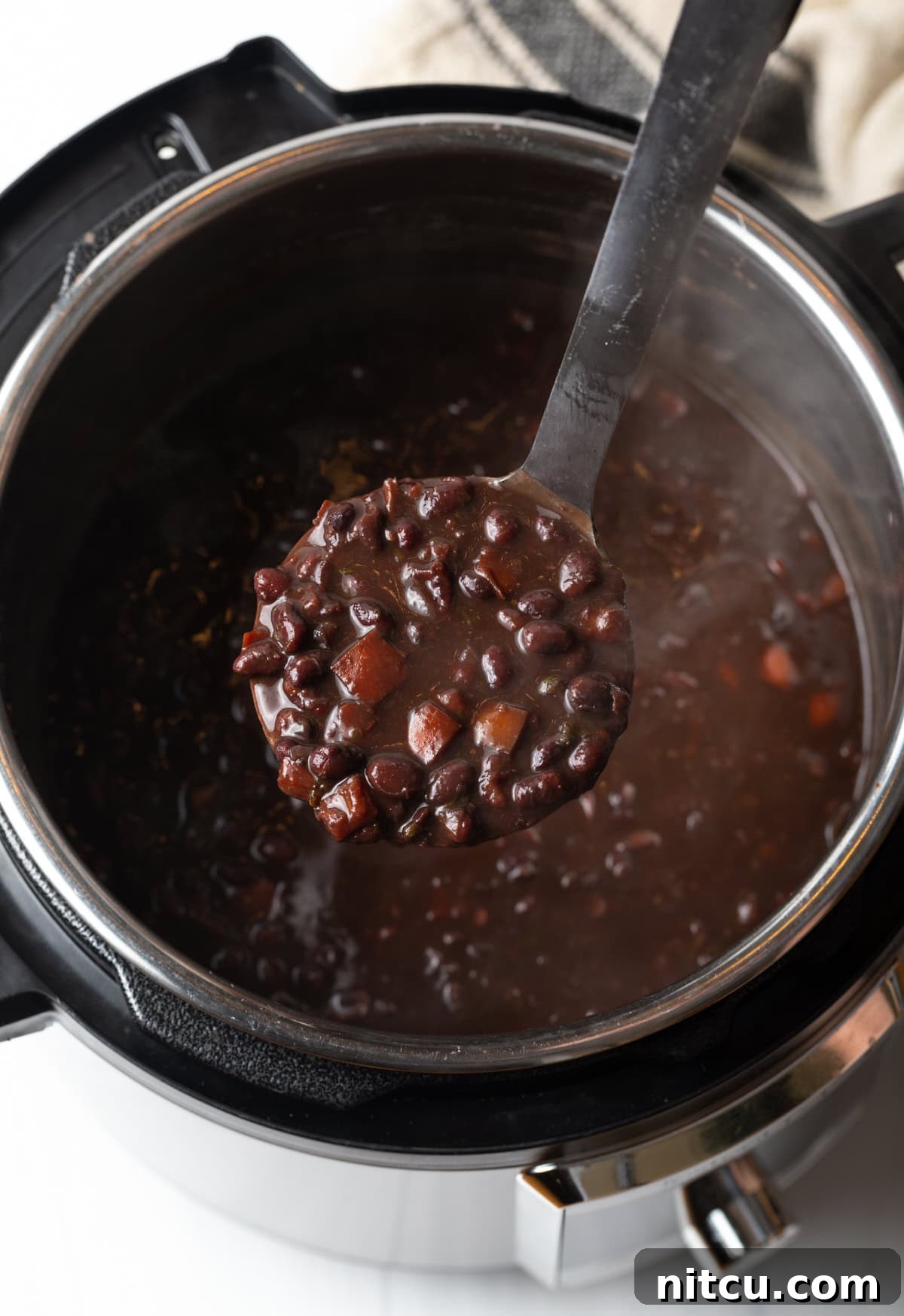 Hearty Black Bean Soup 7 Ladle with black bean soup over an instant pot.