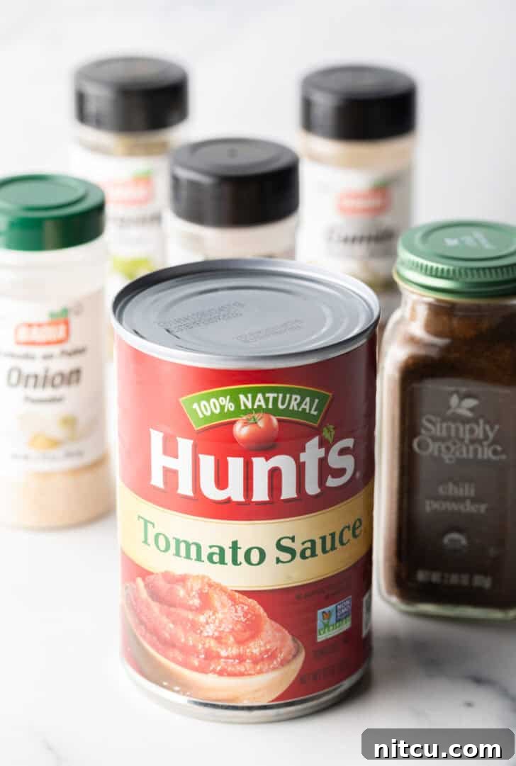 Authentic Red Enchilada Sauce 5 Ingredients you need: Can of tomato sauce, various spices in jars like chili powder, ground cumin, garlic powder, and onion powder.
