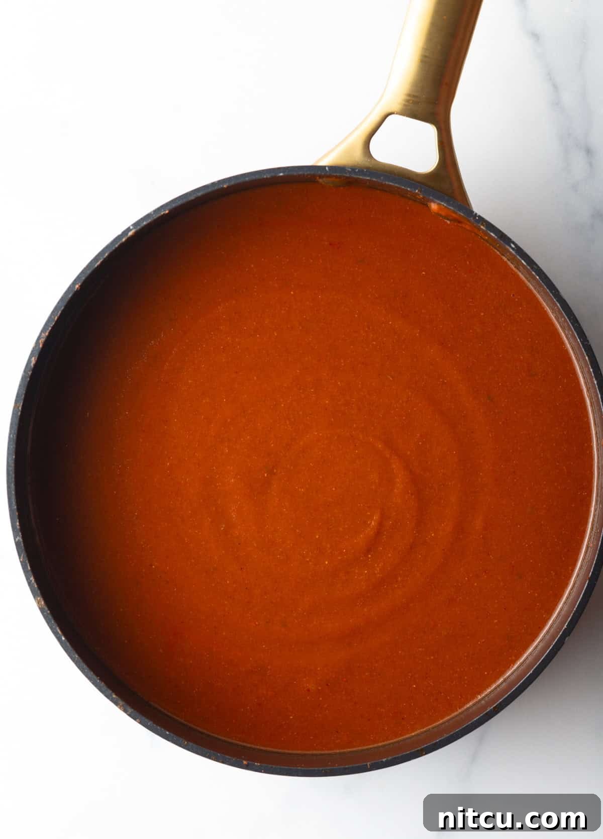 Authentic Red Enchilada Sauce 9 Top down view large deep skillet of red sauce.