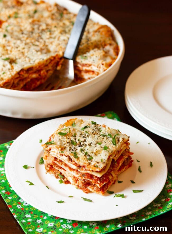 Homemade Cream Cheese Lasagna | ASpicyPerspective.com #Lasagna #Pasta Sausage Lasagna Recipe with cream cheese and Italian sausage cut on plate - ready to serve! A delicious homemade meal.