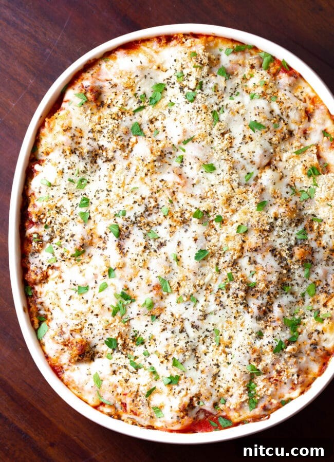 Homemade Lasagna with Sausage and Cream Cheese | ASpicyPerspective.com #Lasagna #Pasta Overhead shot of a baked cream cheese lasagna in a pan, bubbling and golden brown, ready for serving.