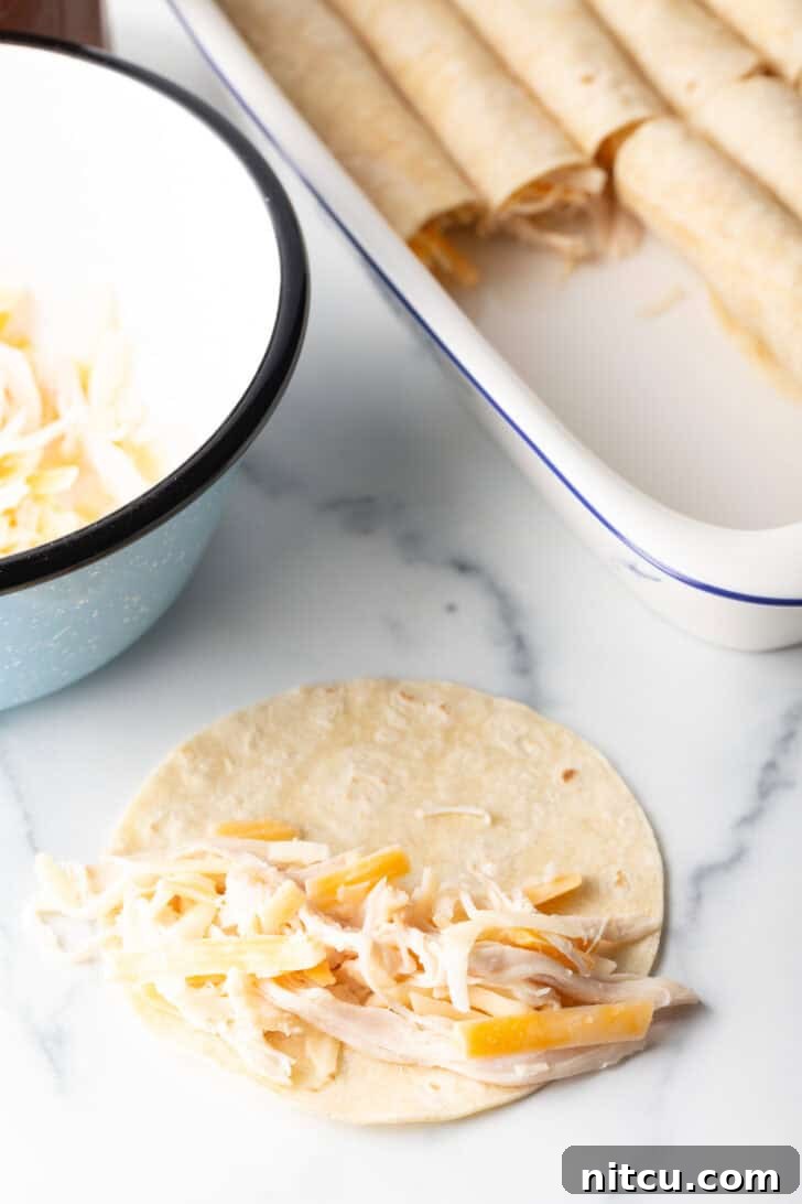 Grandma's Secret Enchiladas 6 Tortilla with shredded chicken and cheese, ready to roll and place in a baking dish with other enchiladas.