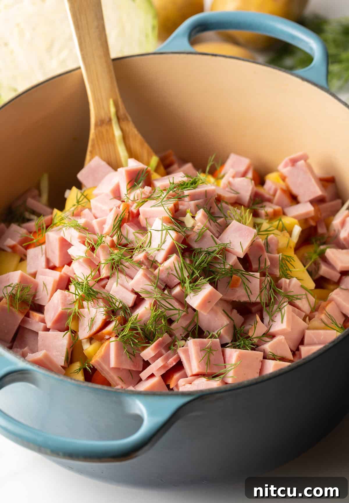 Comforting Ham and Cabbage Pot 5 Large blue cooking pot with diced ham, veggies and fresh spices.