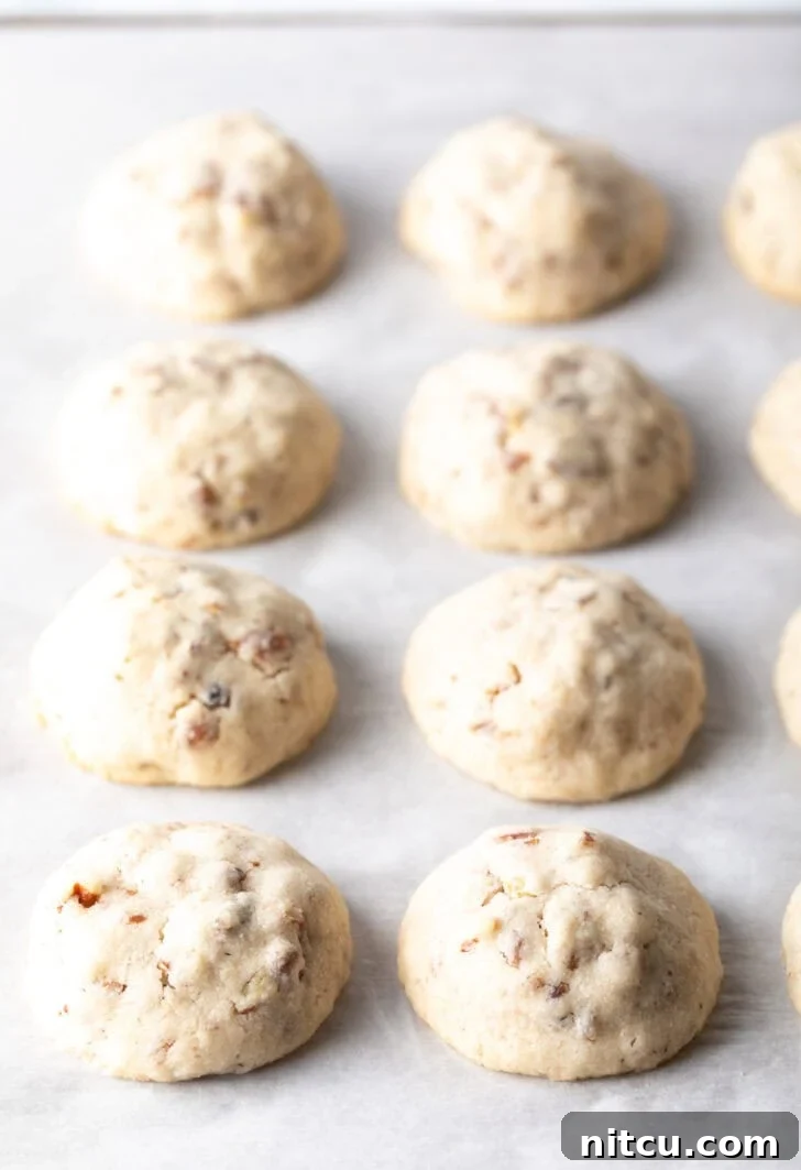 8 baked Russian tea cake cookies on parchment.