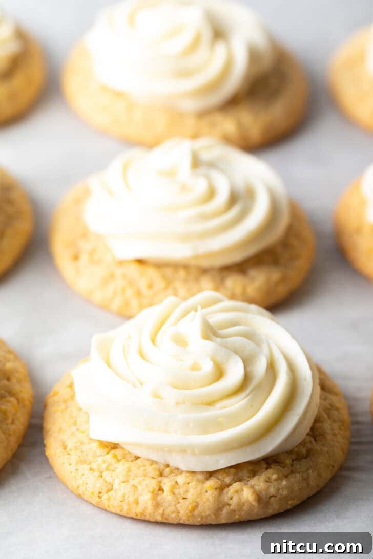 Honey Butter Cornbread Delights 2 Several honey butter cornbread cookies on a white background, each topped with piped frosting.
