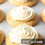 Honey Butter Cornbread Delights 12 Several honey butter cornbread cookies on a white background, each topped with piped frosting.