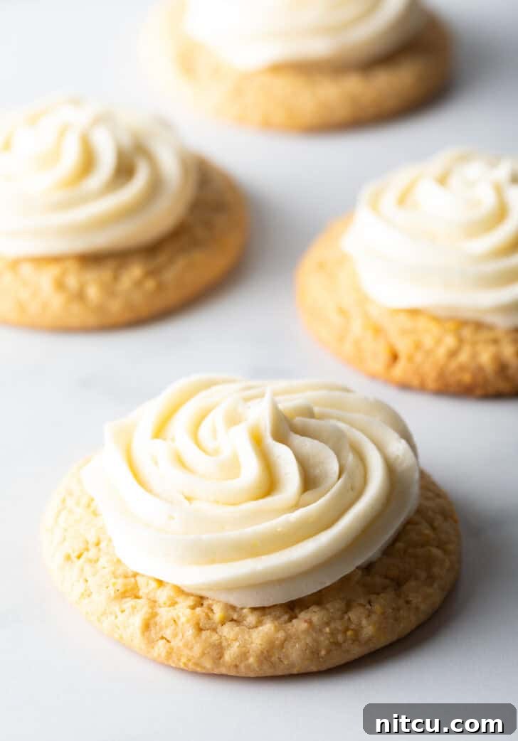 Honey Butter Cornbread Delights 10 Several honey butter cornbread cookies on a white background, each topped with piped frosting.