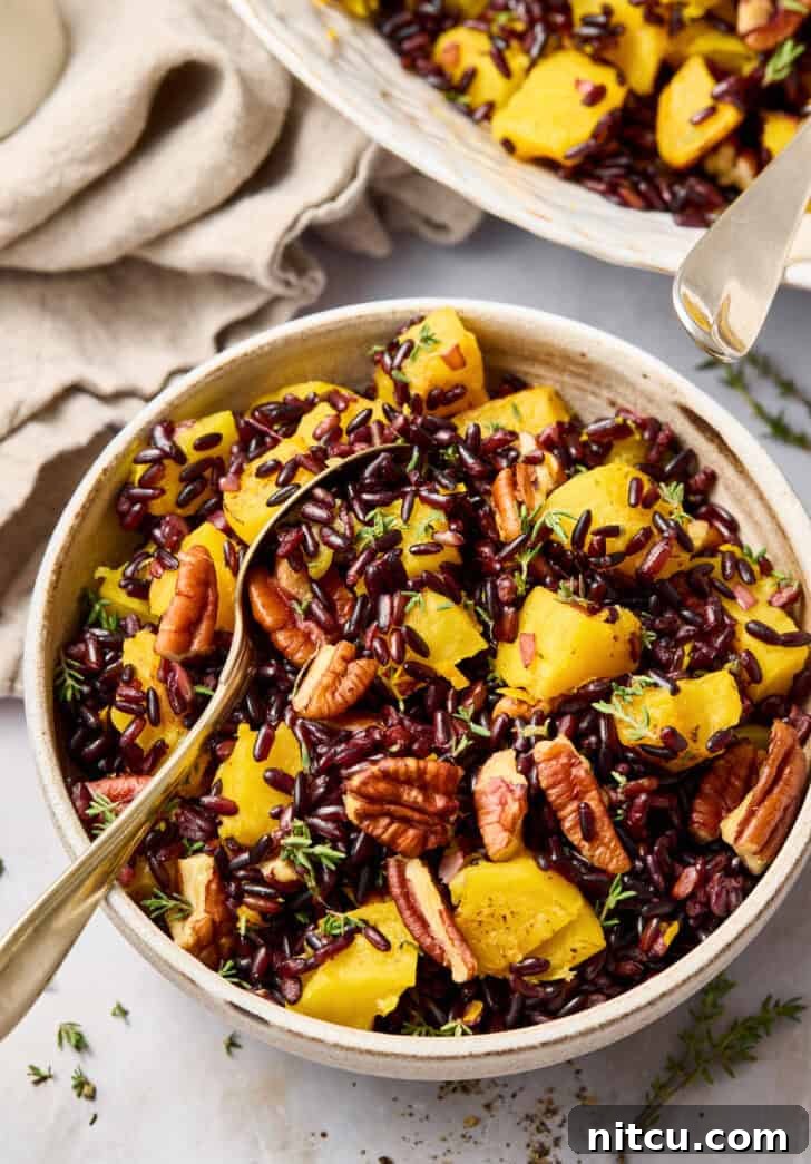 forbidden rice Forbidden Rice Recipe in a small bowl with a spoon, showing pecans and squash.