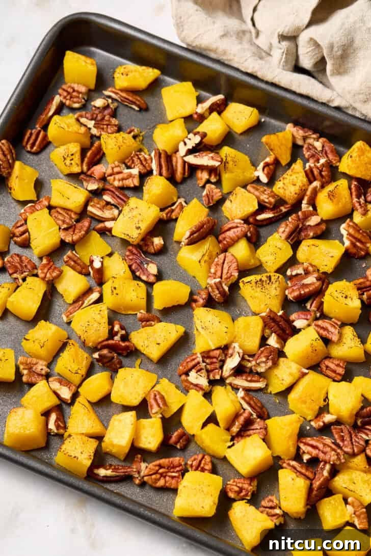 fall-recipe Roasted acorn squash and pecans on a baking sheet, a perfect fall combination.