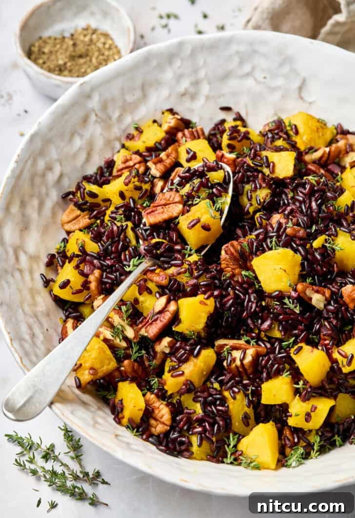 Royal Purple Rice Dish 6 Black Rice Recipe in a white bowl with a spoon, garnished with butternut squash.