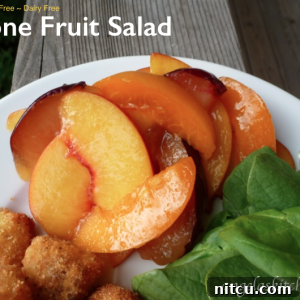 Close-up of fresh stone fruit salad with honey-lime dressing and vibrant mint garnish