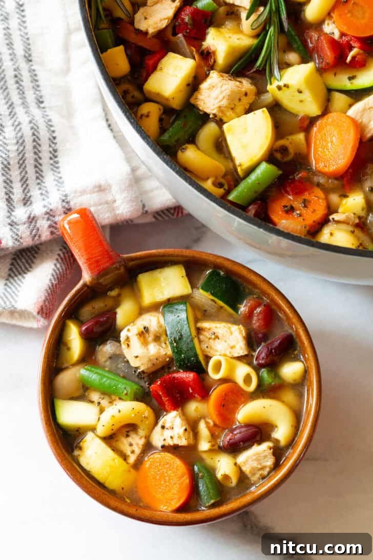 A top-down view of a large mug with a handle, filled to the brim with flavorful meat minestrone soup, ready for a cozy meal.