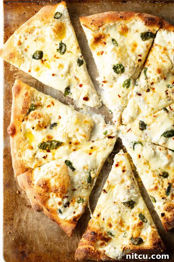 Homemade White Pizza Perfection 4 Top down view of a white pizza cut into 8 slices on a baking sheet.