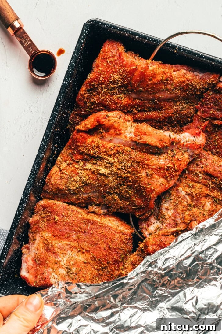 Fall-Off-The-Bone Oven Ribs 7 Ribs wrapped in foil baking in the oven for tenderness