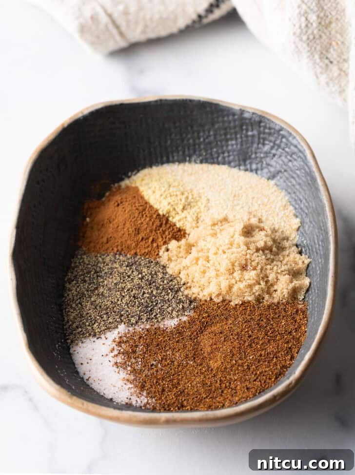 Signature Pork Chop Seasoning 6 Oval bowl with different spices separated into piles before mixing.