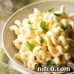 Large bowl of Boursin cheese pasta garnished with chopped parsley.