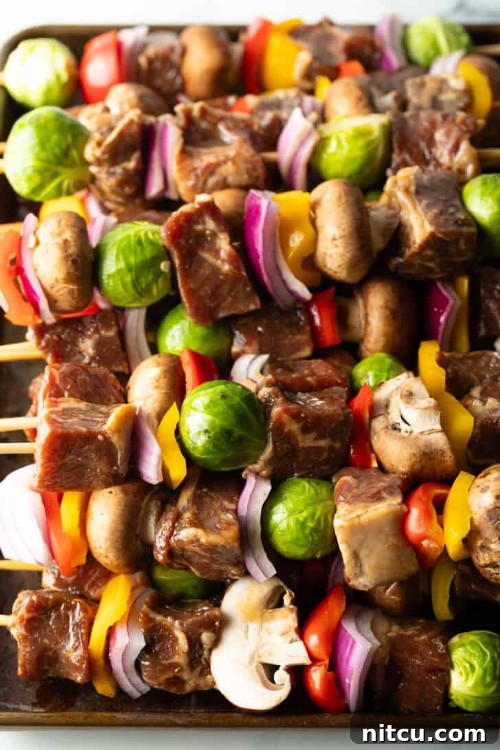 Skewers loaded with alternating pieces of marinated beef and colorful vegetables, ready for the grill.