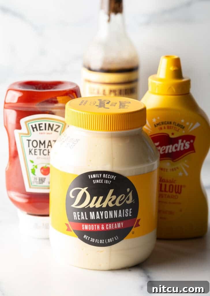 Signature Burger Dressing 5 Individual bottles and jar of the four core ingredients: mayonnaise, yellow mustard, ketchup, and Worcestershire sauce, neatly arranged on a surface.