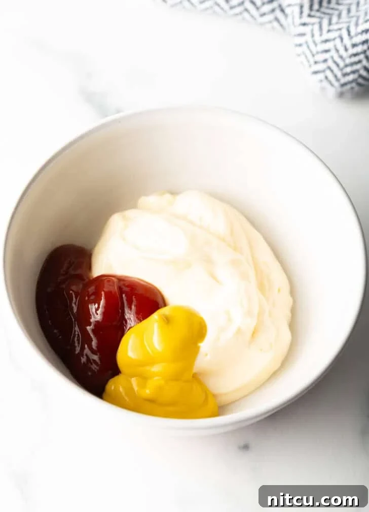 Signature Burger Dressing 6 Mayonnaise, yellow mustard, and ketchup are combined in a pristine white mixing bowl, ready to be whisked into a sauce.