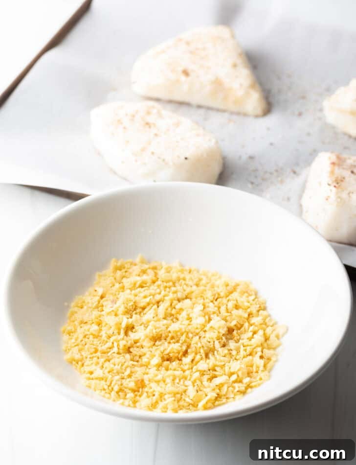 Close-up of crushed salt and vinegar potato chips in a bowl, showing the fine texture ready for coating the fish.