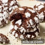 Mexican Mocha Crinkle Cookies Recipe stacked on plate with bite taken out of top cookie
