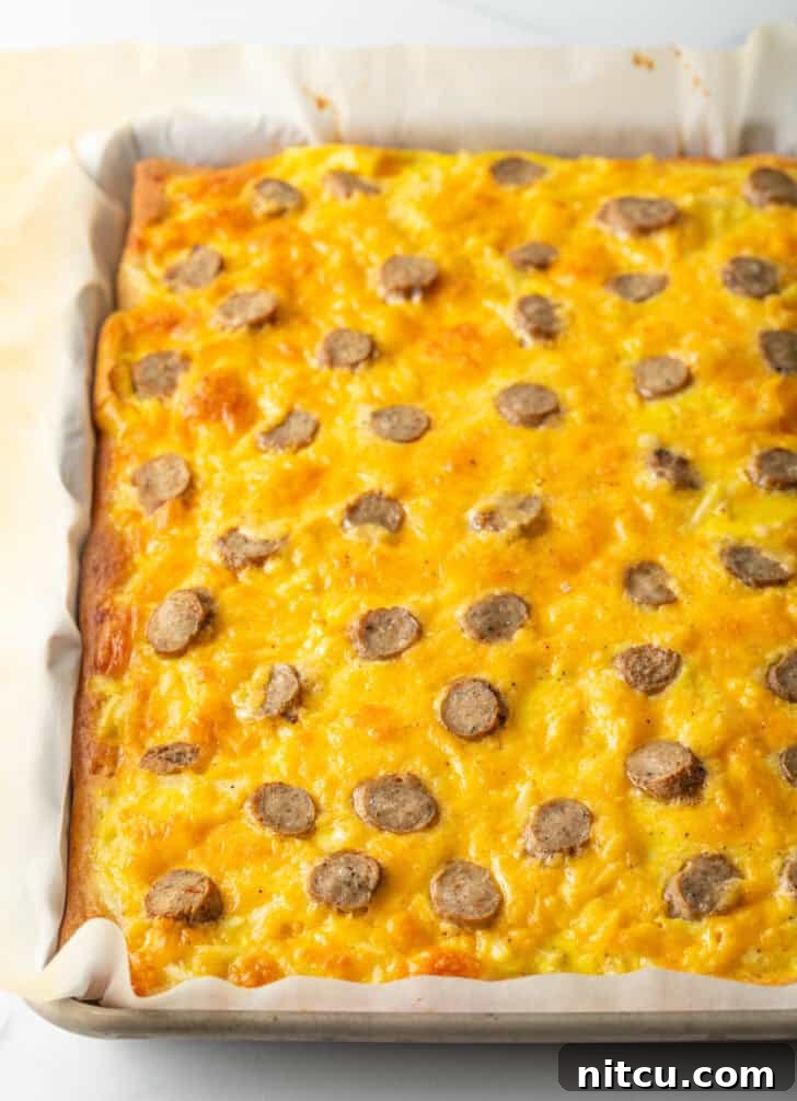 Daybreak Pizza 9 A fully baked rectangular pizza, glistening with melted cheeses and topped with perfectly cooked sausage slices, fresh out of the oven.