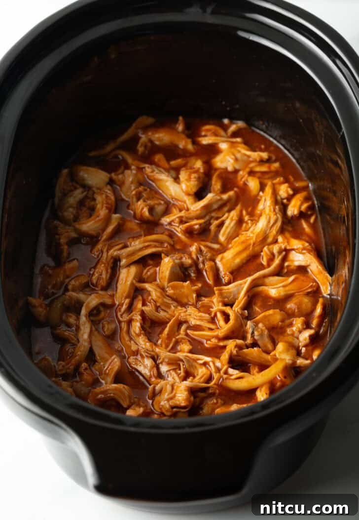 Shredded BBQ chicken in a slow cooker.
