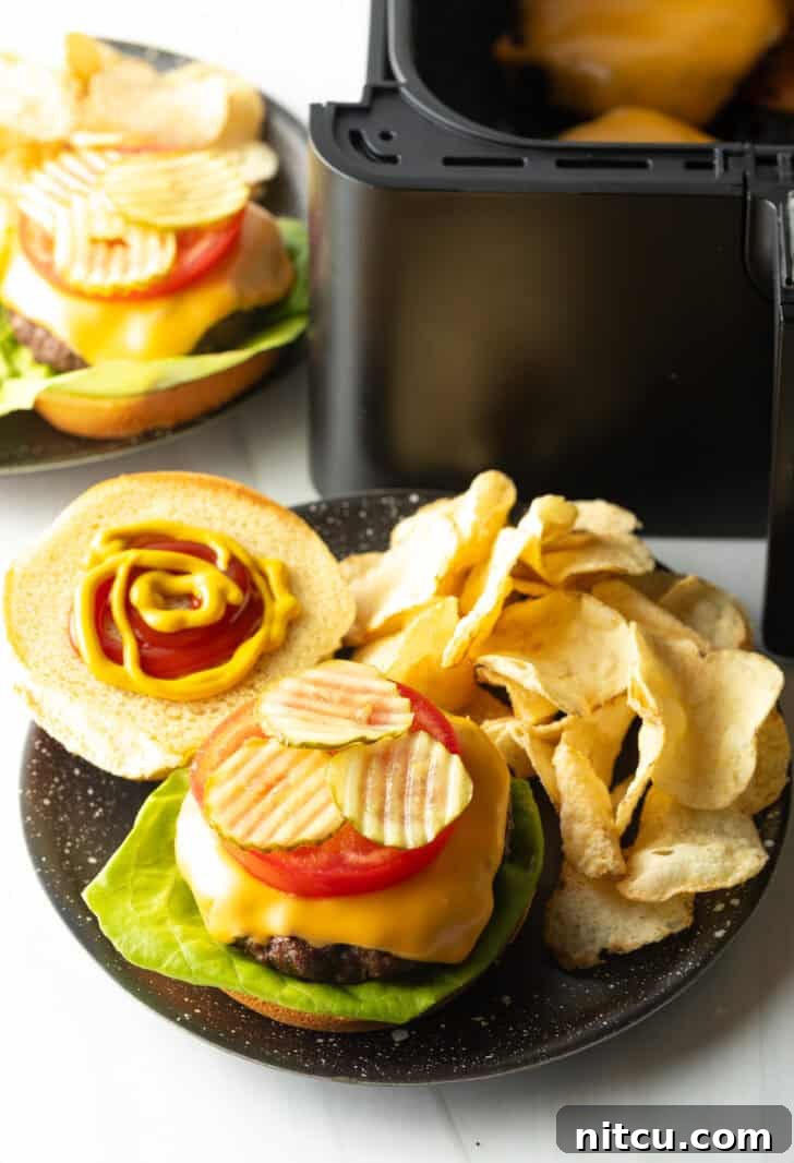 Top down view open faced cheeseburger on a plate with potato chips.