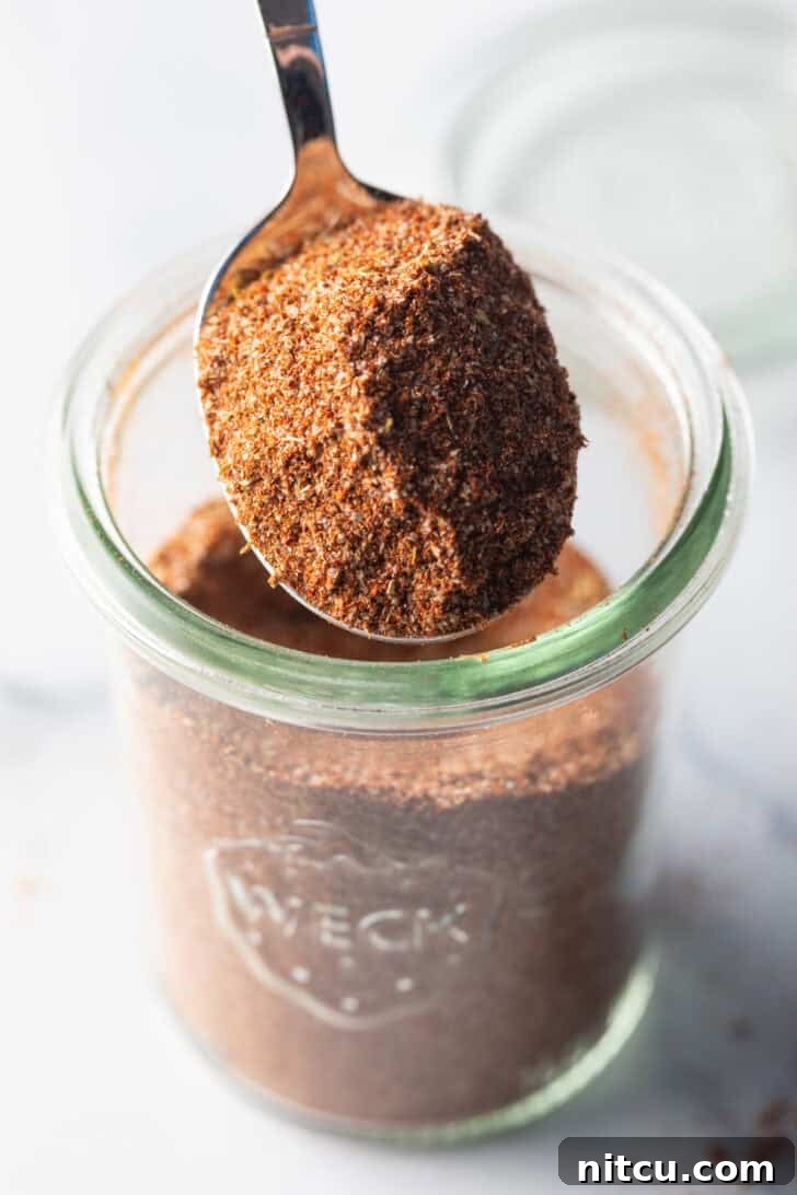 Zesty Chicken Taco Blend 2 A spoonful of rich, homemade chicken taco seasoning held up, showcasing its beautiful color and texture. Perfect for enhancing chicken dishes.